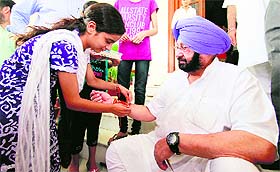 A girl ties a rakhi to Capt Amarinder Singh in Patiala on Sunday.