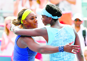 Serena Williams and Venus Williams hug after the semifinal, which Venus won, of the Rogers Cup in Montreal on Saturday