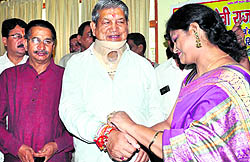 A woman ties a rakhi to Chief Minister Harish Rawats wrist at his residence at Beejapur Rest House in Dehradun on Sunday