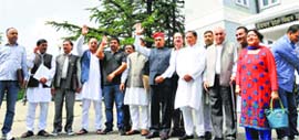 Former Chief Minister Prem Kumar Dhumal with other BJP MLAs raise slogans as they walk out of the monsoon session in Shimla on Monday.