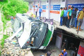 Onlookers gathered near the ill-fated HRTC bus that rolled down from the road at Dhayarghat village, 20km from Shimla.
