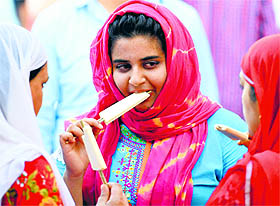 Women enjoy ice-cream in Srinagar on Monday.