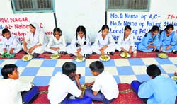 Students have a mid-day meal at a school. A Tribune photograph
