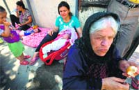 Iraqi Christians, who fled the violence in Iraqs largest Christian town of Qaraqosh, rest in the garden of Ainkawas Saint Joseph church on the outskirts of Arbil on Tuesday. AFP