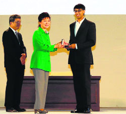 South Korean President Park Geun-Hye (C) gives the prize to Manjul Bhargava (R) at a ceremony in Seoul