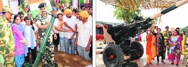 DIG, BSF, Amritsar sector, MF Farooqui, tells visitors about the weaponry during an arms exhibition organised at the Attari-Wagah joint check-post to commemorate the 67th Independence Day celebrations; and (right) BSF jawans explain the working of the weapons used by the BSF.