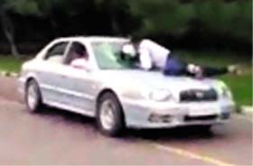 Video snapshots of a UT police constable Devinder Singh atop the bonnet of a car near the Sectors 9/10/16/17 roundabout on Sunday. The constable kept hitting the windowpane with his helmet even as the driver refused to apply brakes.