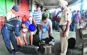 Policemen frisk passengers and their belongings at the ISBT, Sector 43, Chandigarh, on the eve of the Independence Day on Thursday.