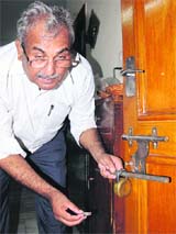 Meher Chand Thakur shows the broken lock at his house.