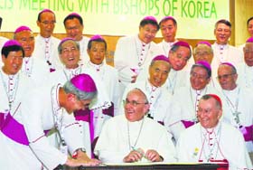 Pope Francis (bottom C) smiles as he signs the guest book after a meeting with the bishops at the headquarters of the Korean Bishopss Conference in Seoul on Thursday
