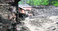 Houses and a bridge collapse during a heavy rain at Kataula in Mandi on Saturday. Photo: Jai Kumar