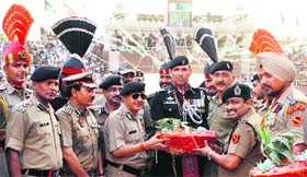 BSF officials hand over sweets to Pakistan Rangers at the Wagah border