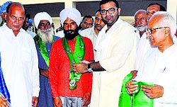 Karan Singh Chautala (second from right) gives robes to new INLD entrants in Sirsa on Sunday as party nominee from Sirsa Makhan Lal Singla (extreme left) looks on