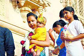 a child dressed as Lord Krishna at a temple