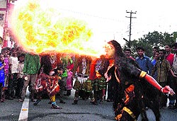 An artist performs a fire stunt during a yatra on the occassion of Janmashtami in Dehradun on Sunday