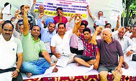 Members of the Joint Action Coordination Committee of the Zirakpur Societies, hold a protest in Zirakpur on Monday.