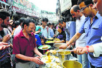 Devotees queue up for langar outside a temple on Janmashtami in Shimla on Monday.