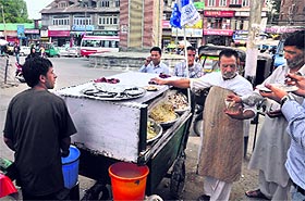Aalu pallay seller Nazir Ahmed Qureshi, known as Nazir Palley, attends to his customers at Lal Chowk in Srinagar on Monday.
