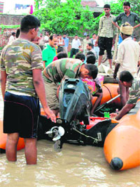 NDRF jawans rescue villagers from flood-affected villages in Khanpur in Haridwar on Monday. 