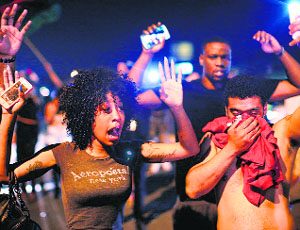 Demonstrators protesting the killing of teenager Michael Brown by a Ferguson police officer try to stand their ground despite being overcome by tear gas on in Ferguson, Missouri. 