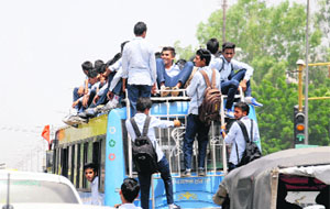Students travel atop a private bus in Bathinda on Tuesday.