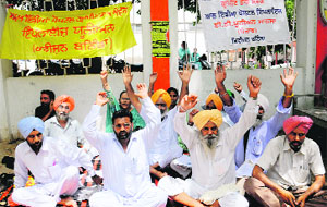 Members of the Rural Post Office Employees Union stage a dharna in Bathinda on Tuesday.