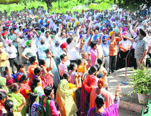 Members of the Punjab School Education Board Employees Union protest outside the office gate at Phase VIII in Mohali on Tuesday.