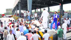 High drama: Villagers gather at the Kherki Daula toll plaza in Gurgaon on Tuesday