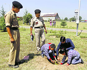 Schoolchildren plant a chinar sapling at the BSF Kashmir Frontier in Srinagar on Tuesday.