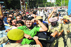 Police stop Public Health Engineering Department employees during a protest in Srinagar on Tuesday. 