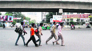 A group of people cross the BMC chowk in Jalandhar on Tuesday. 