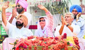 Congress leader Capt Amarinder Singh and his son Raninder Singh campaign for party candidate for Patiala Assembly byelection Preneet Kaur during a roadshow in Patiala on Tuesday.