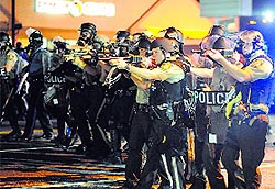 Law enforcement officers watch on during a protest on West Florissant Avenue in Ferguson, Missouri