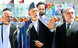 Afghan President Hamid Karzai (C) speaks during celebrations to commemorate Afghanistans 95th anniversary of independence as he is flanked by presidential candidates Abdullah Abdullah (R) and Ashraf Ghani in Kabul on Tuesday