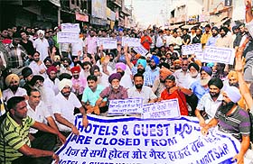 Hoteliers along with their family members and religious sect leaders stage a protest against the move to seal the hotels, guest houses and inns targeted by the Special Investigation Team in Amritsar on Wednesday.