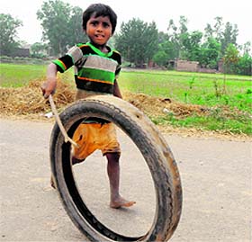 A child plays with a tyre at a village near Amritsar