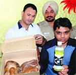 Police officials show two sand boa snakes and venom seized from a bus in Hallo Majra. Tribune photo: Nitin Mittal
