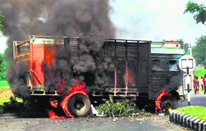 A truck set on fire by protesters on National Highway-39 at Pura Bangla in Golaghat, Assam, on Wednesday.