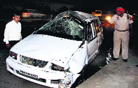 Police official take a look at the damaged Swift and tavera that hit a couple on GT Road in Jalandhar on Wednesday
