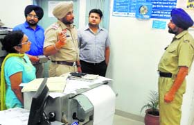 A police official gives security tips to the staff of a bank at Dehlon