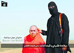 A still from the video, which shows a man, believed to be a US journalist, kneeling in front of a masked militant