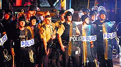 Policemen watch as demonstrators protest the killing of teenager Michael Brown in Ferguson, Missouri