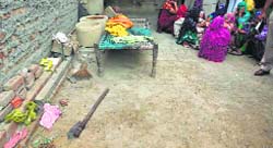 Relatives grieve near the spot where Ram Pal was killed in his sleep in Jinds Julana village on Thursday. Also seen is the weapon used in the crime. Tribune photo