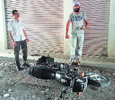 A biker has a fall after skidding on the scattered pebbles on the road in front of the Sanjay Gandhi market in Jalandhar.