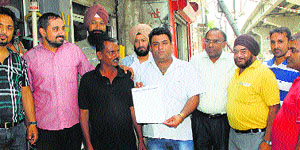 Shopkeepers of Old Railway Road with the man they nabbed with a fake letterhead in Jalandhar on Thursday.