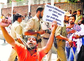 A daily wage employee holds a noose around his neck as policemen try to disperse them during their protest march in Srinagar on Thursday.