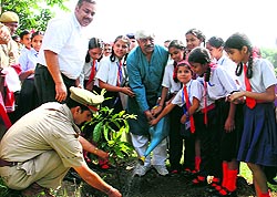 A policeman plants a sapling at the Hathibarkala campus of Survey of India as part of the Van Mahotsava celebrations on Thursday
