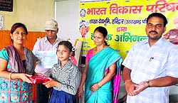 A talented student being given prize for her brilliant performance in a drawing event on the Kedarnath valley flash floods, at Madho Rao Devley School at Chandi Ghat in Haridwar on Thursday