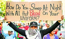 A woman joins several hundred others in Oakland during a protest against the shooting of Michael Brown, an unarmed black 18-year old by a white police officer in Ferguson, on Wednesday