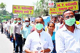 Revenue officials hold silent protest march at the Parade Ground in Dehradun on Friday.